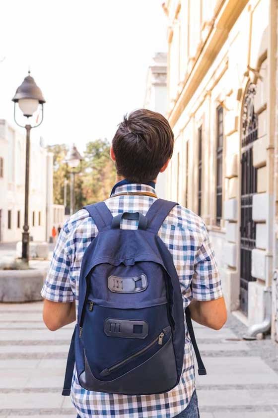 Una persona camina por una calle llena de vida y alegría, simbolizando la experiencia feliz y exitosa que puedes tener durante una estancia de estudios en el extranjero