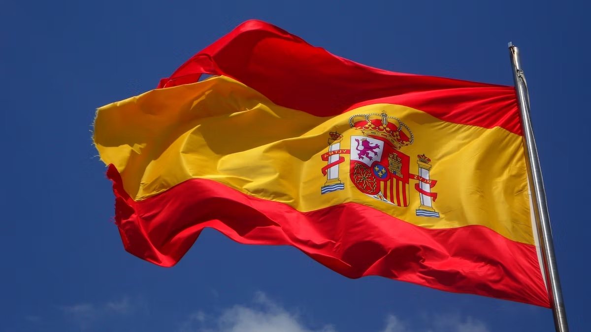 Bandera de España ondeando, símbolo de trabajar en España y obtener permiso de trabajo para extranjeros.